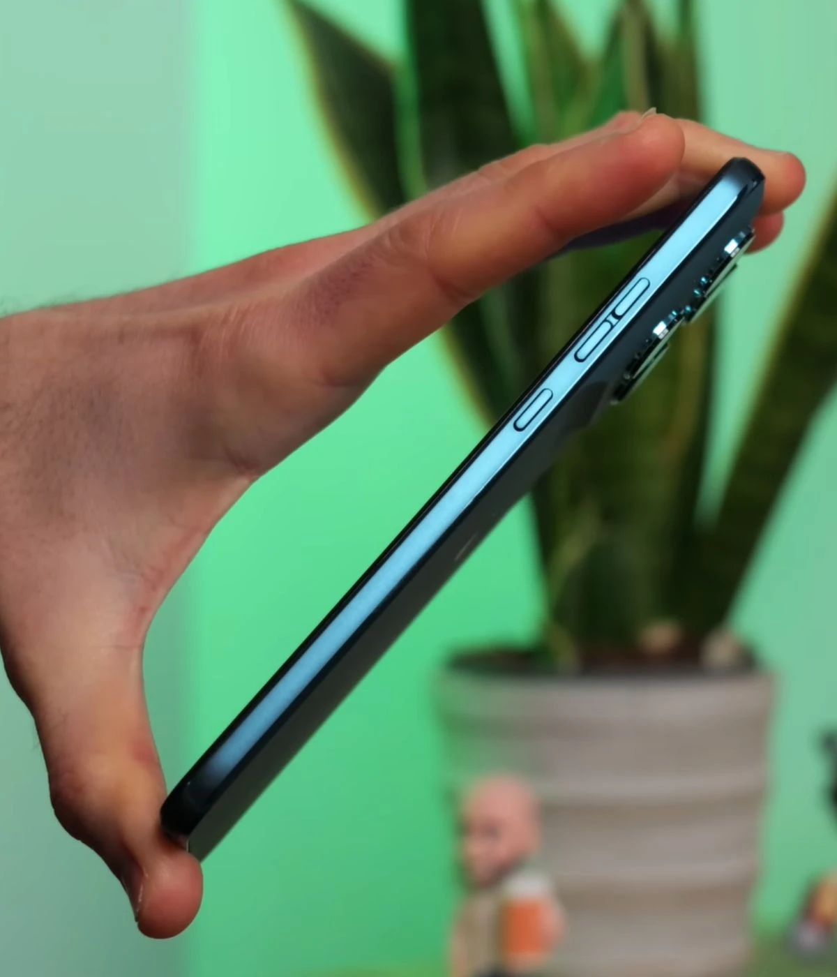 Motorola G77 smartphone held in hand showing side profile with buttons