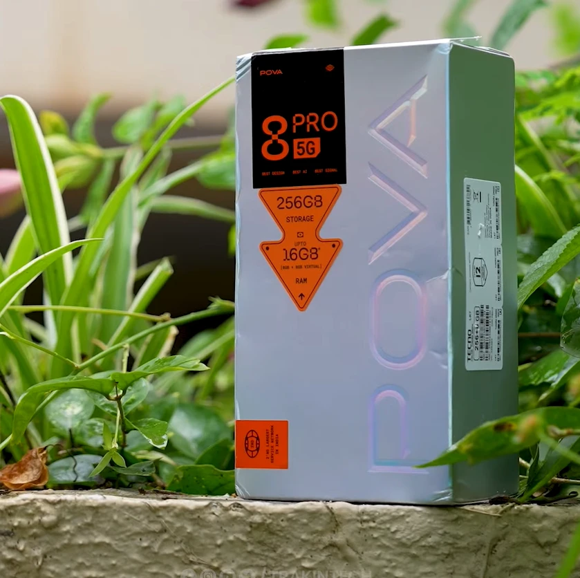 Tecno Pova 8 Pro 5G smartphone box with specifications in a green outdoor setting
