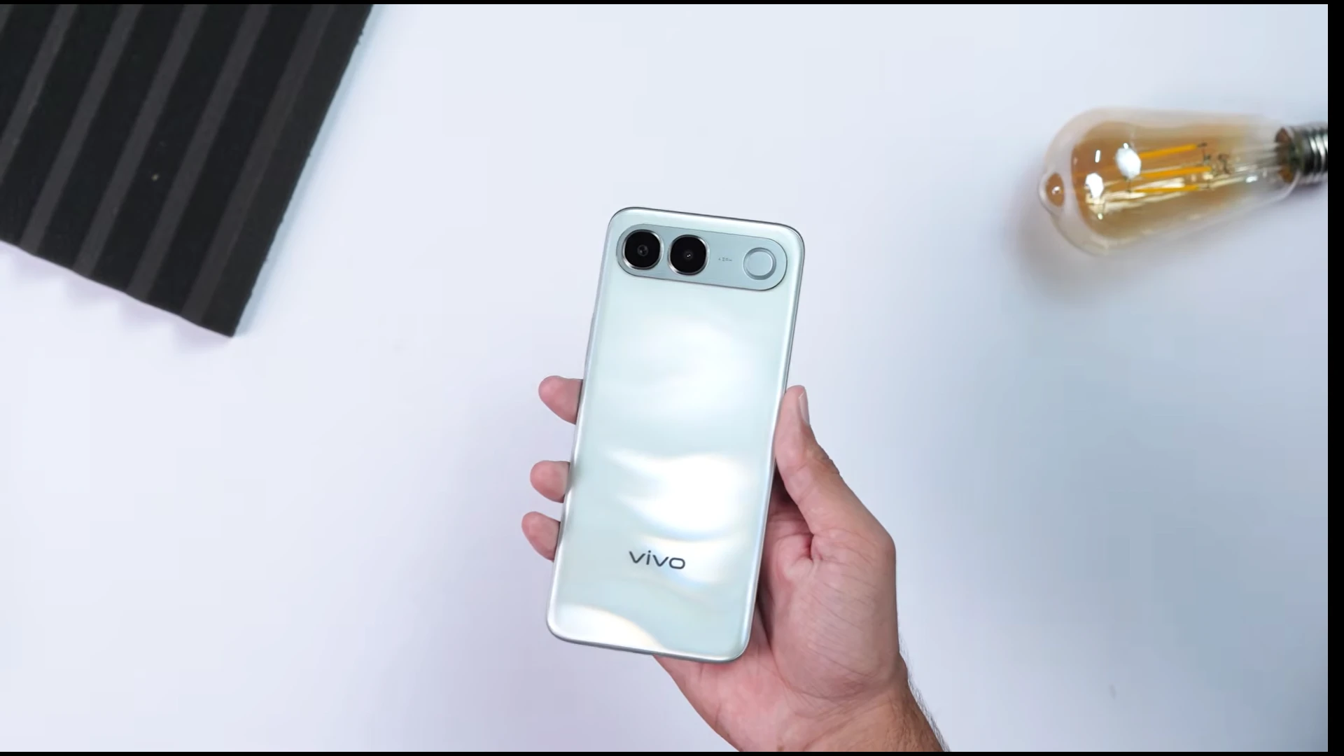 Vivo V80 Lite 5G smartphone held in hand with a stylish design and camera features.